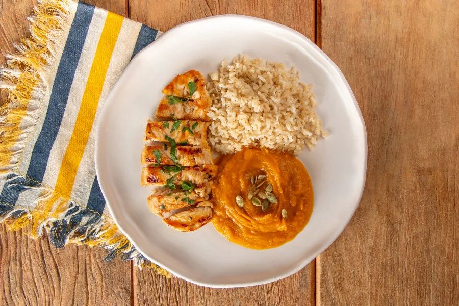 Iscas de frango com arroz e purê de abóbora cabotiá